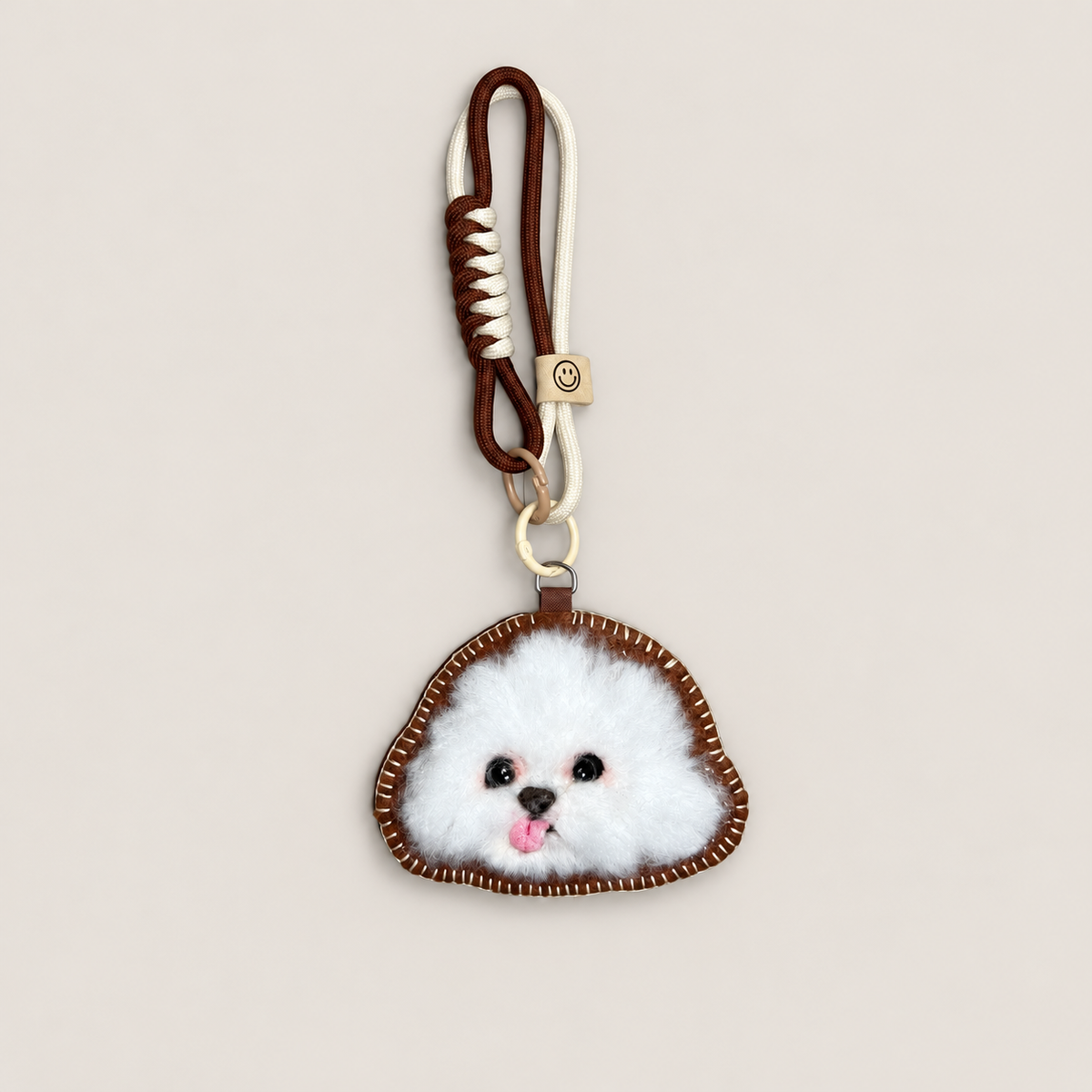 Handmade wool-felt white fluffy dog charm with cord strap, front view